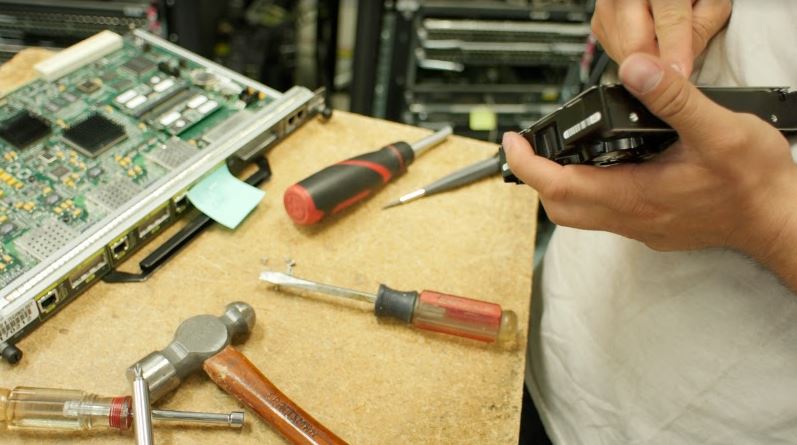 IT person working on hardware with tools